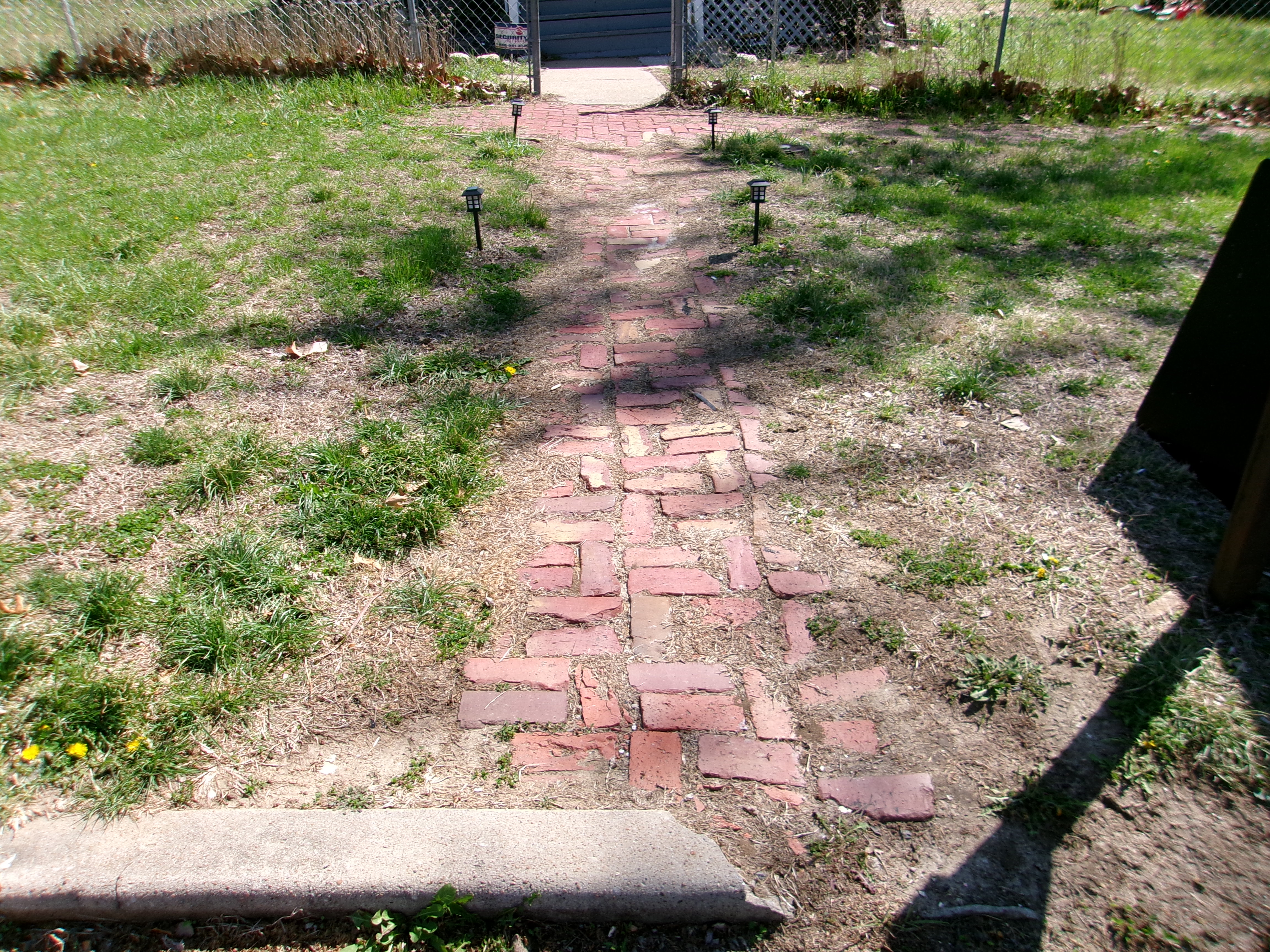 Brick sidewalks overgrown with grass in Leavenworth